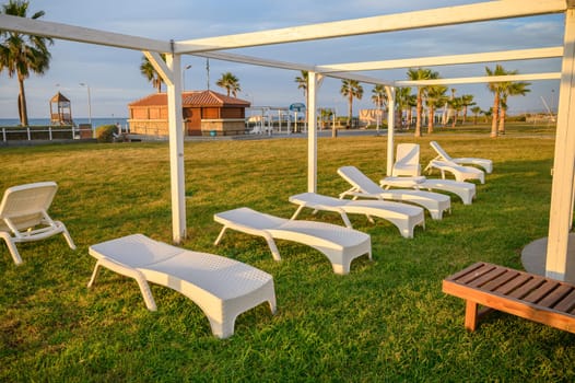 white plastic sun loungers on the Mediterranean sea