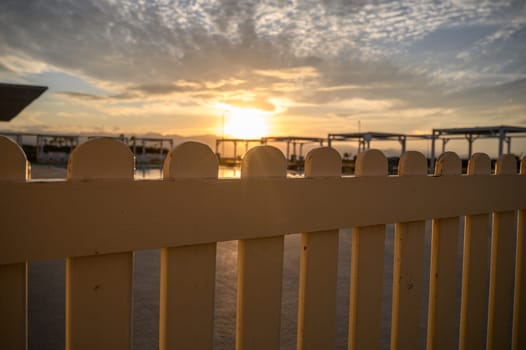 white fence sunset and sea and mountain views