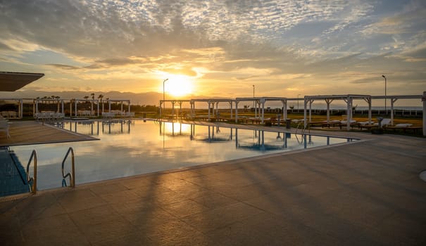 swimming pool in a residential complex on the seashore in sunset light