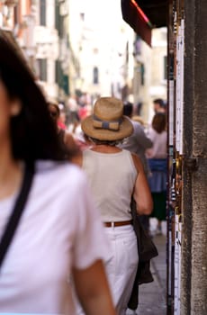 A woman in hat Venice. A lady in a beautiful hat walks