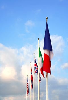 Flags of America, Italy, France of the European Union. National waving flag of united states on pole against blue cloudless sky