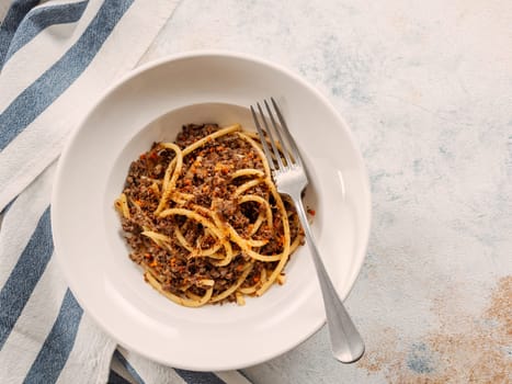 Spaghetti bolognese with minced meat or Makarony Po Flotski or Russian Navy Style Pasta. Top view. Navy spaghetti in plate, copy space.