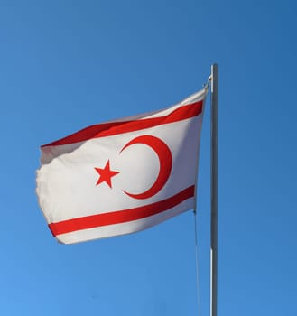 flag of the Turkish Republic of Northern Cyprus against a blue sky