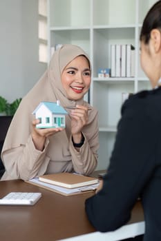 Muslim woman real estate agent and client discussing home purchase, insurance, mortgage or investment home loan.