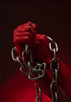 bloodied hands clenched into fists in the shackles of a metal chain symbolize slavery, protest and struggle for freedom