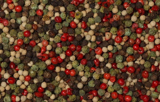 Background of mixed peppercorns, black, green, white and pink, natural spice condiment pattern texture, elevated top view, directly above