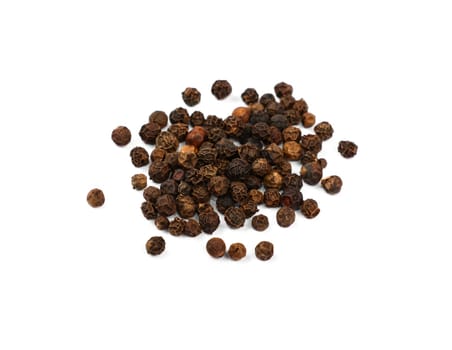 Close up heap of black pepper peppercorns spilled and spread around isolated on white background, high angle view