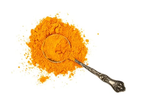 Close up one vintage metal spoon full of yellow turmeric spice powder spilled and spread around isolated on white background, elevated top view, directly above