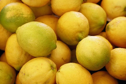 Close up fresh yellow lemon fruits on retail display of farmer market, high angle view