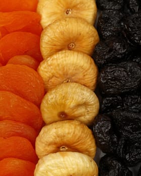 Close up background pattern of assorted sundried fruits, plums, apricots, figs, high angle view