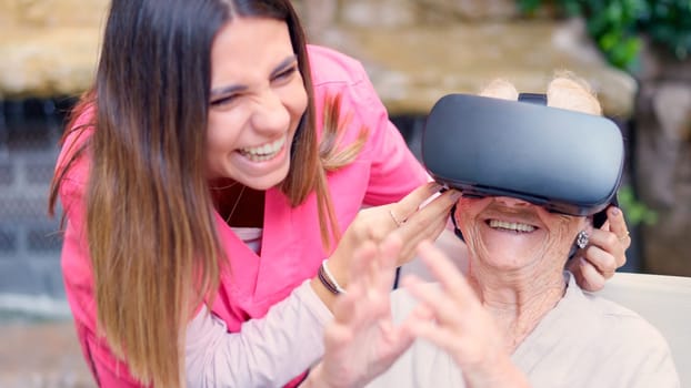 Photo of an elder woman gesturing while using virtual reality goggle in geriatric