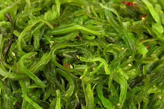 Extreme close up background of green wakame seaweed salad, elevated top view, directly above