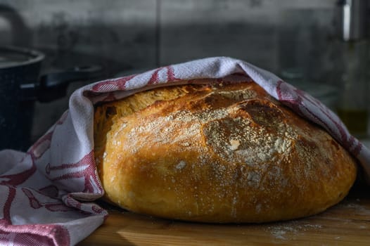 freshly baked homemade bread in the kitchen under a towel