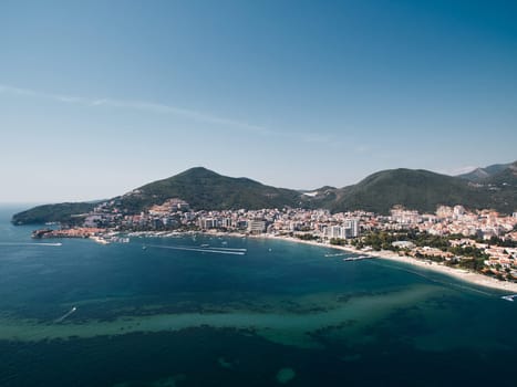 Motorboats sail along the Bay of Kotor opposite the resort coast of Budva. Montenegro. Drone. High quality photo