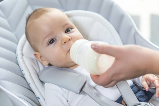 Newborn baby drinking water from bottle, healthcare concept