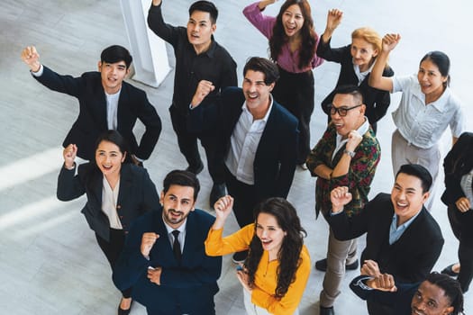 Happy diverse business people celebrating their success project.Top view. Group of successful energetic employees cheer up gratefully while looking at sky with white background. Intellectual.