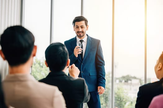 Business leaders present reviews to diverse audience of colleagues in a meeting room, where active listening and participation are key. embodies the concept of successful teamwork and collaboration.