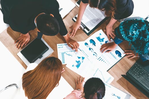 Top view of businessman executive in group meeting with other businessmen and businesswomen in modern office with laptop computer, coffee and document on table. People corporate business team uds