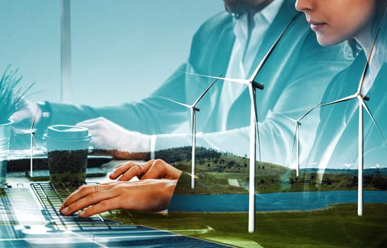 Double exposure graphic of business people working over wind turbine farm and green renewable energy worker interface. Concept of sustainability development by alternative energy. uds