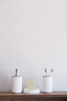 bathroom soap dispenser and toothbrush cup.