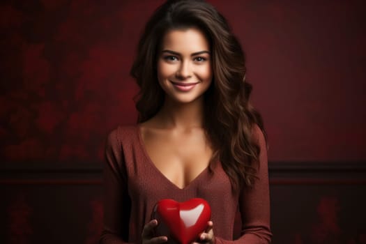 A beautiful woman with a heart-shaped red toy against a red backdrop, ideal for an advertising poster, banner, or heartfelt greeting card
