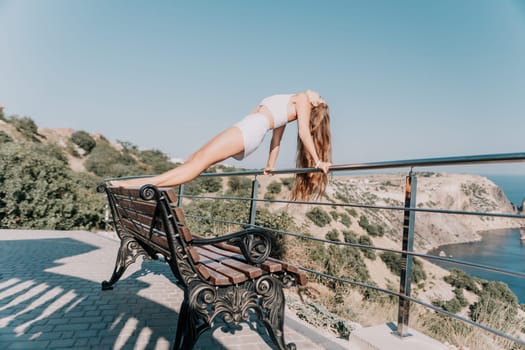 Fitness woman sea. Outdoor workout on yoga mat in park near to ocean beach. Female fitness pilates yoga routine concept. Healthy lifestyle. Happy fit woman exercising with rubber band in park.