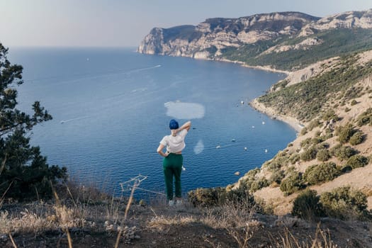 Happy woman standing with her back in nature in summer with open hands posing with mountains. Woman in the mountains, eco friendly, summer landscape active rest.