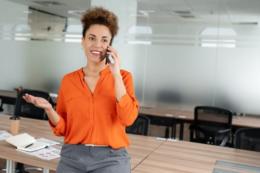 Small business entrepreneur smiling while communicating with her office colleagues