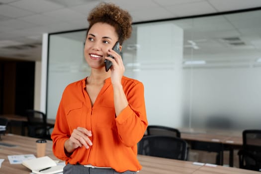 Small business entrepreneur smiling while communicating with her office colleagues