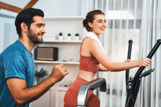 Athletic and sporty young couple or fitness buddy running on running machine together, home body workout exercise session as healthy sport lifestyle at home. Gaiety home exercise workout training.