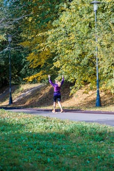 Autumn running in the park: girl enjoying jogging among autumn trees and colors