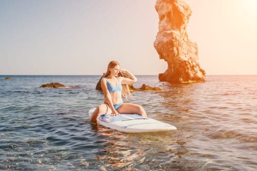 Close up shot of happy young caucasian woman looking at camera and smiling. Cute woman portrait in bikini posing on a volcanic rock high above the sea