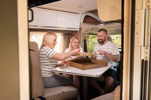 A family of three is playing a board game while sitting in a motorhome.