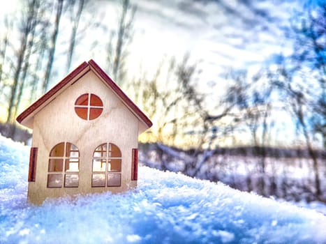 Wooden toy house on snow, natural abstract background. winter season concept. symbol of cozy, loving family home. construction, sales, rental concept. Christmas and new year holidays. copy space