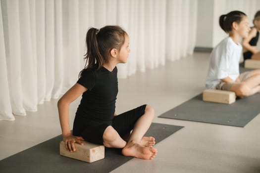 Children do yoga in the gym on support blocks. Children's gymnastics.