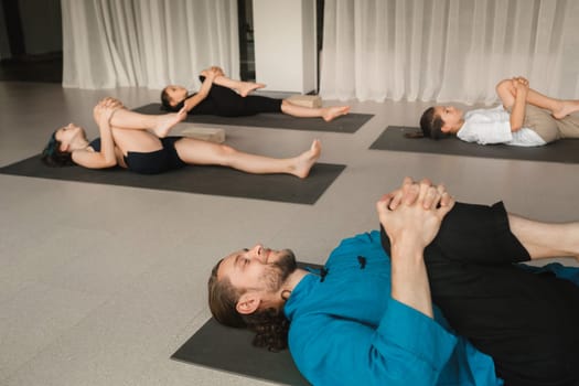 Children do yoga in the gym under the guidance of an instructor. Children's gymnastics.