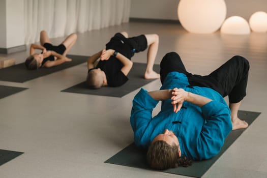 Children do yoga in the gym under the guidance of an instructor. Children's gymnastics.