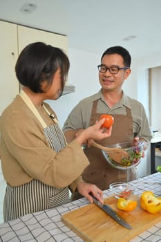 Shot of a happy retired couple preparing a healthy vegetarian meal in the kitchen. Healthy lifestyle concept.