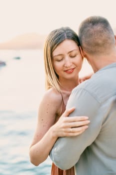 Young woman hugs the shoulders of man hugging her waist. High quality photo