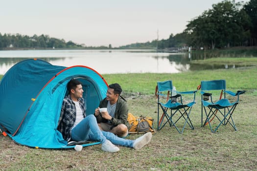 Gay LGBTQIA couple relax and drinking tea and coffee while camping on vacation holiday.