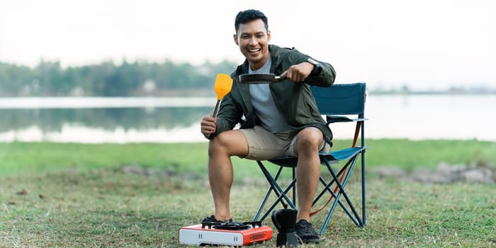 Asian man travel and camping alone at natural park in Thailand. Recreation and journey outdoor activity lifestyle.
