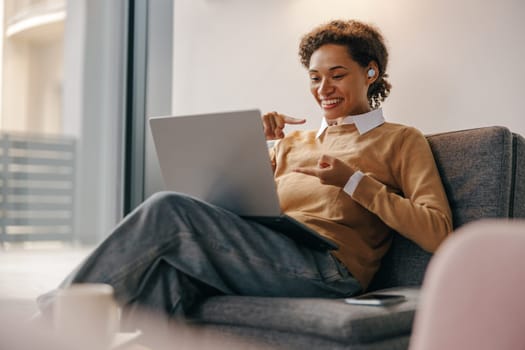 Positive female freelancer have online meeting while sitting in cozy coworking during working day