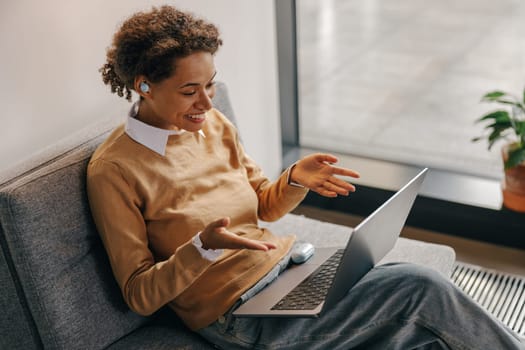 Positive female freelancer have online meeting while sitting in cozy coworking during working day