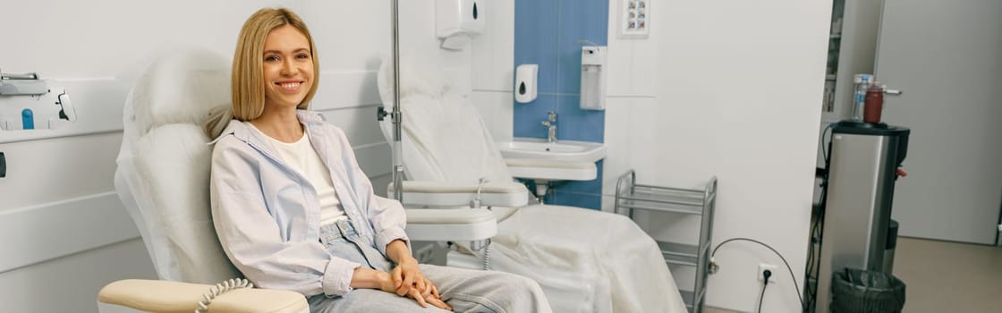 Woman sitting in armchair while waiting for IV infusion in hospital. High quality photo