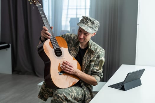 Veteran Guitar Play Concept. Family Meeting. Camouflage Uniform. Resting Together. Feelings Showing. Patriotic Comeback. Paralyzed Soldier. High quality photo