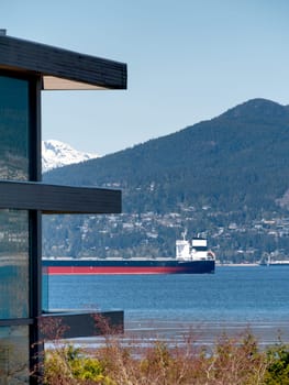 Ocean-going cargo vessel in Coal harbor bay in Vancouver. View from residential area