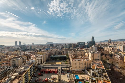 Panoramic picture of Barcelona city stretching to horizon. Combination of buildings from different years in old and modern city under cloudy sky. Urban lifestyle