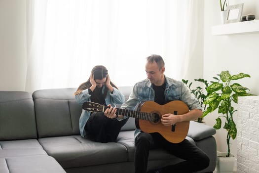 Happy family Father and daughter playing guitar. Father's day. High quality photo