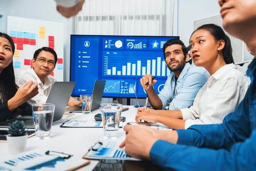 Analyst team utilizing BI Fintech to analyze financial data at table in meeting room. Businesspeople analyzing BI dashboard power for business insight and strategic marketing planning. Prudent