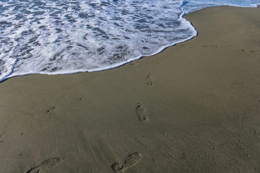 footprints of a woman on the beach of the Mediterranean Sea